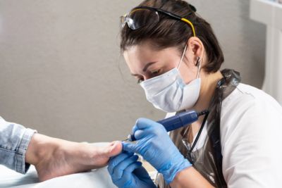 Professionnelle utilisant du matériel de pédicure de qualité.